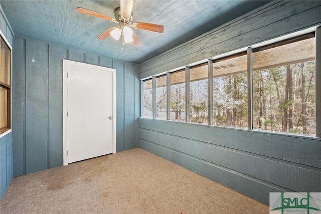 unfurnished sunroom featuring ceiling fan