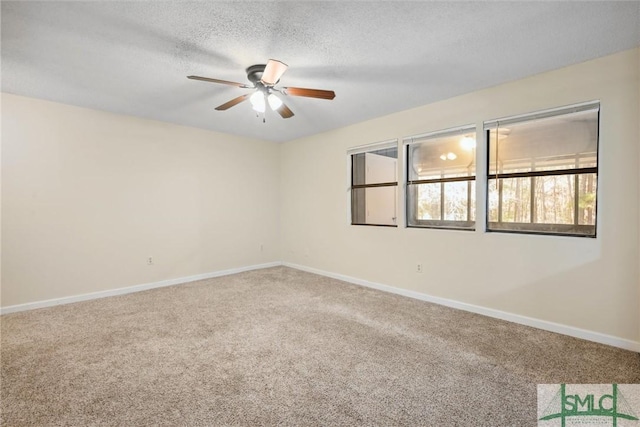 carpeted empty room featuring baseboards, a textured ceiling, and a ceiling fan