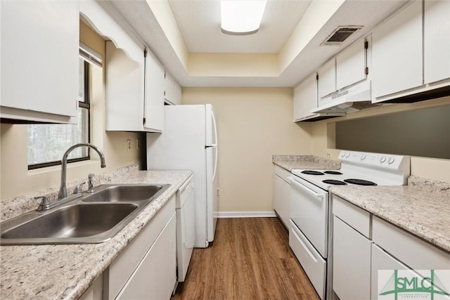 kitchen featuring white appliances, dark wood-style floors, visible vents, a sink, and under cabinet range hood