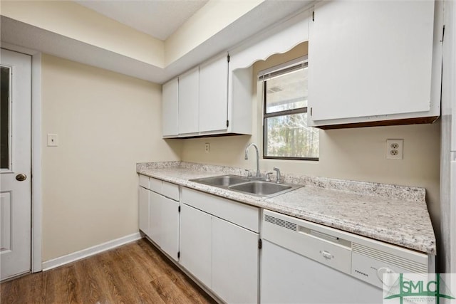 kitchen featuring baseboards, light countertops, wood finished floors, white dishwasher, and a sink