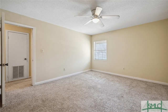 carpeted empty room with baseboards, visible vents, a textured ceiling, and ceiling fan