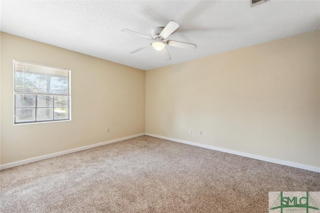 carpeted empty room with baseboards, a textured ceiling, and ceiling fan