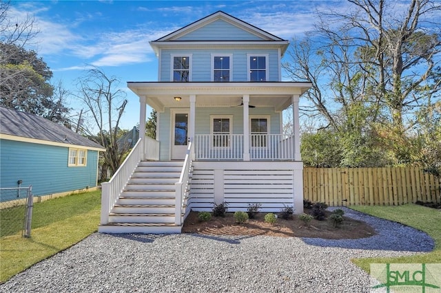 view of front facade with a ceiling fan, a porch, stairs, and fence