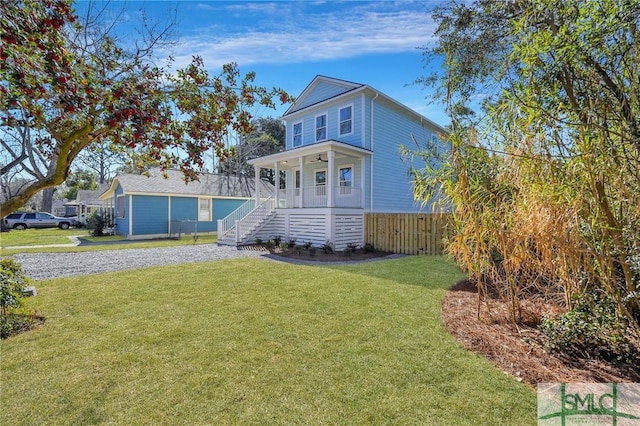 view of front of home with a front lawn, a porch, fence, ceiling fan, and stairs