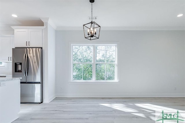 unfurnished dining area with baseboards, ornamental molding, recessed lighting, light wood-style flooring, and an inviting chandelier