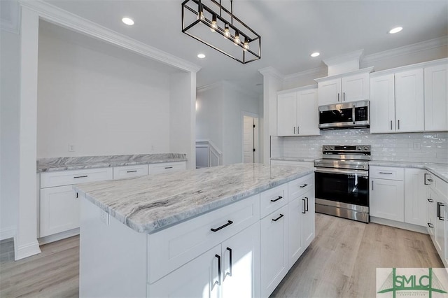 kitchen featuring a kitchen island, crown molding, decorative backsplash, light wood-style floors, and stainless steel appliances