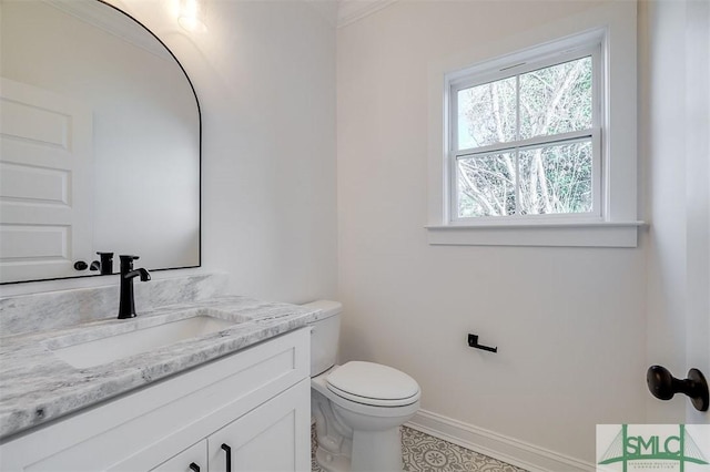 bathroom featuring vanity, toilet, and baseboards