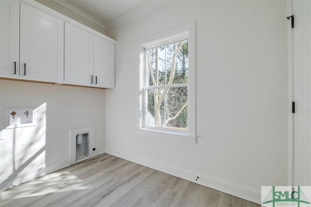 washroom featuring cabinet space, crown molding, baseboards, and washer hookup