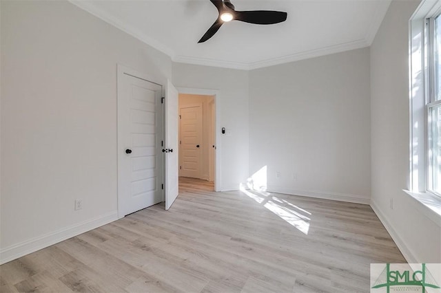 spare room with light wood-type flooring, baseboards, and crown molding