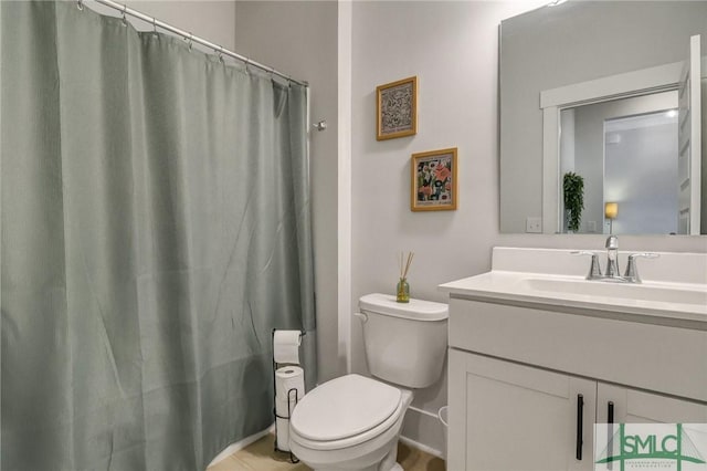 bathroom featuring toilet, vanity, and a shower with curtain