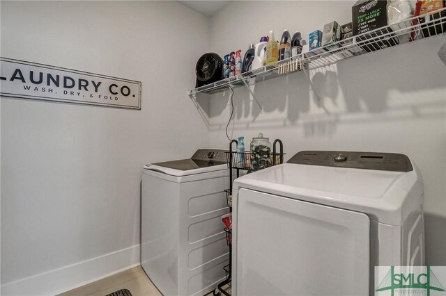 laundry area with baseboards, laundry area, and washer and clothes dryer