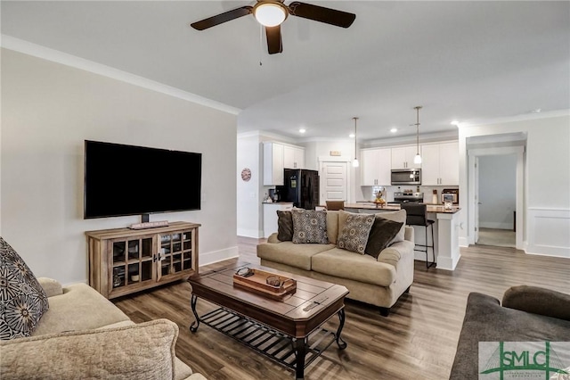 living room featuring crown molding, baseboards, recessed lighting, wood finished floors, and a ceiling fan