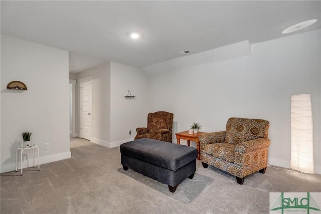 living area with carpet, visible vents, and baseboards