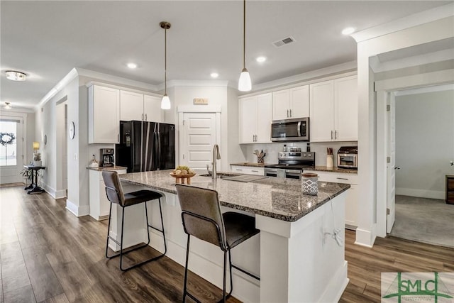 kitchen featuring visible vents, ornamental molding, a sink, dark wood-style floors, and stainless steel appliances