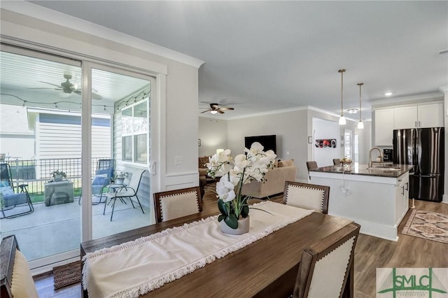 dining room with ornamental molding, a ceiling fan, and light wood finished floors