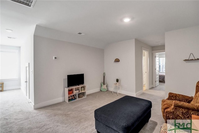 living room featuring visible vents, light carpet, and baseboards