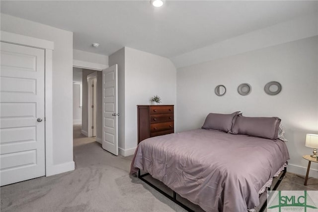 bedroom with light colored carpet and baseboards