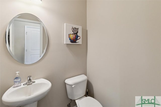 half bathroom featuring toilet and a sink