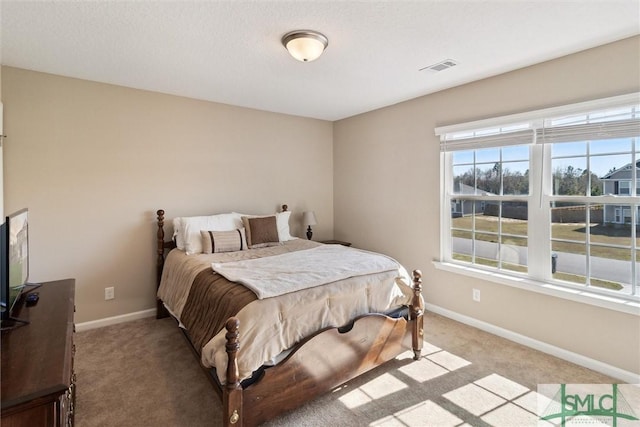 bedroom featuring visible vents, light colored carpet, and baseboards