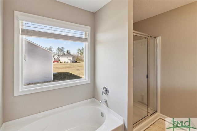 full bathroom with a bath and a shower stall