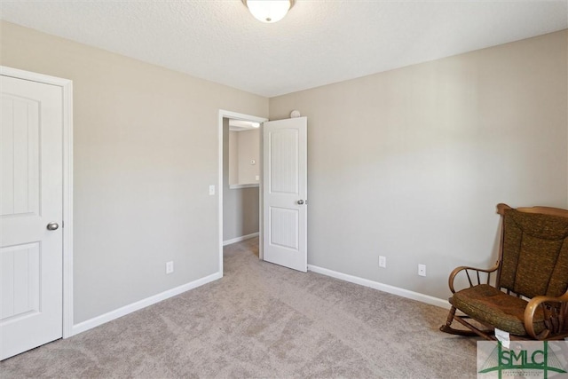 unfurnished room with carpet, baseboards, and a textured ceiling