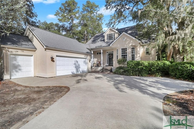 view of front of home with stucco siding, concrete driveway, and a garage