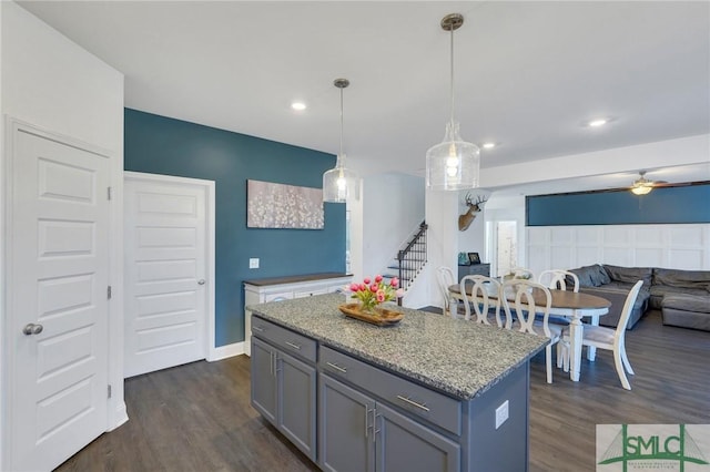 kitchen with dark wood finished floors, decorative light fixtures, open floor plan, and a center island