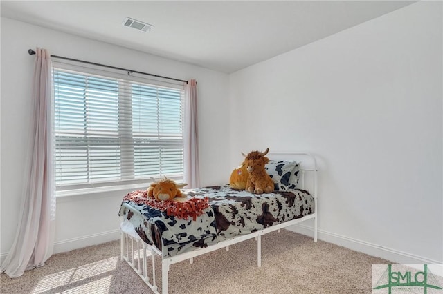 carpeted bedroom featuring visible vents, multiple windows, and baseboards