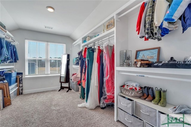 spacious closet with vaulted ceiling, carpet, and visible vents