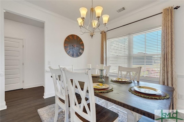 dining room with visible vents, crown molding, baseboards, an inviting chandelier, and wood finished floors