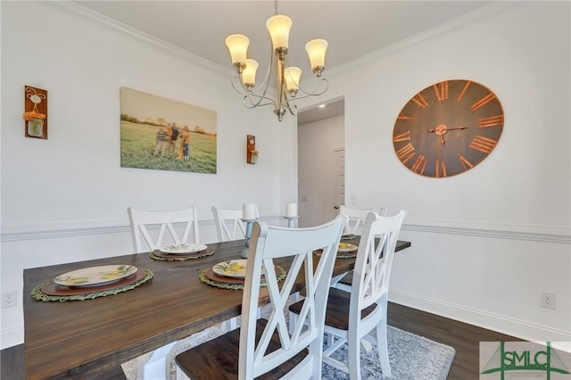 dining space featuring a notable chandelier, wood finished floors, baseboards, and ornamental molding