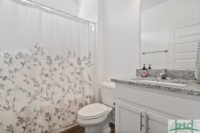 full bath with toilet, a shower with curtain, wood finished floors, and vanity