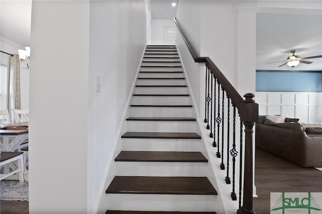stairway featuring ceiling fan and wood finished floors