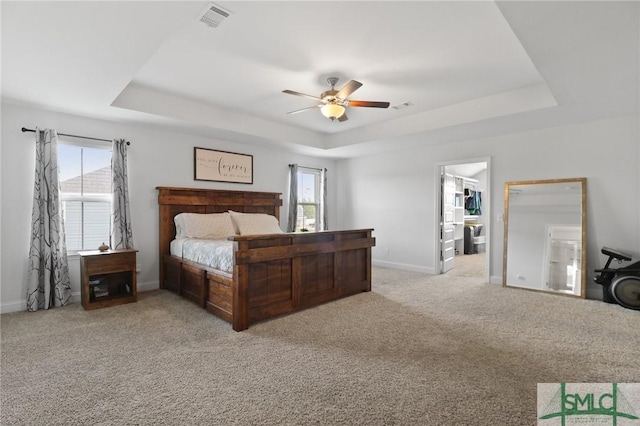 bedroom featuring carpet flooring, baseboards, visible vents, and a raised ceiling