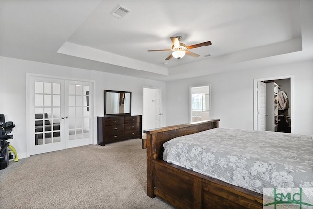 bedroom with ceiling fan, carpet floors, french doors, a tray ceiling, and visible vents