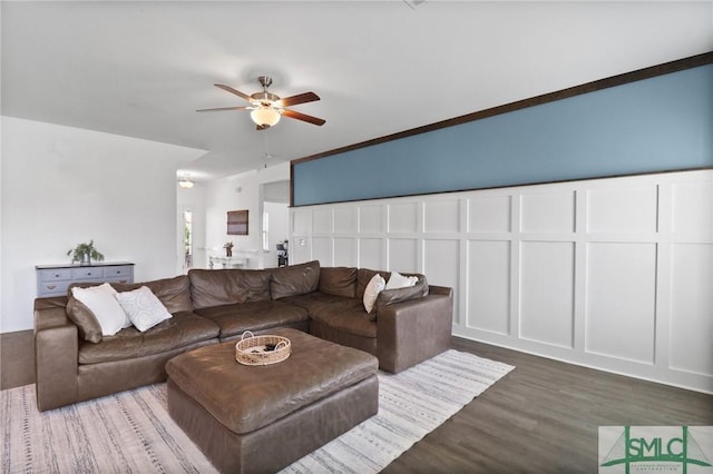 living room with ceiling fan, dark wood finished floors, and a decorative wall