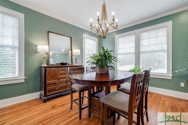 dining room featuring light wood-style flooring, baseboards, and ornamental molding