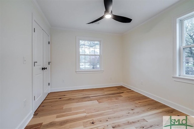 unfurnished bedroom featuring light wood-style flooring, crown molding, baseboards, and multiple windows