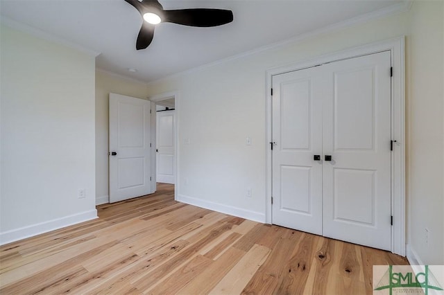 unfurnished bedroom featuring light wood finished floors, a closet, crown molding, and baseboards