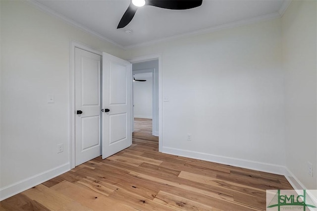 unfurnished bedroom featuring light wood-type flooring, baseboards, a ceiling fan, and crown molding