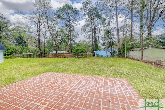 view of yard with a patio, an outdoor structure, and fence