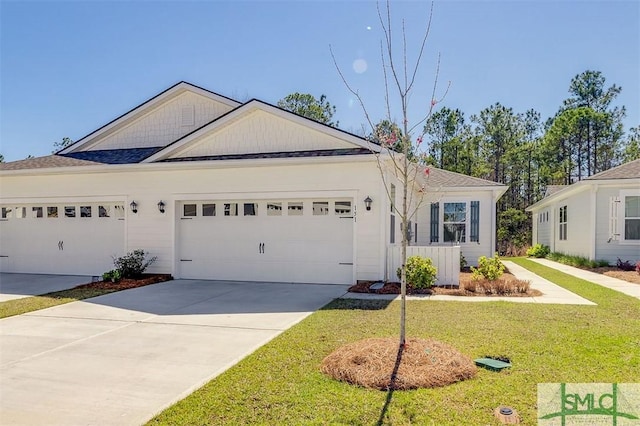 single story home featuring driveway, a front yard, and a garage