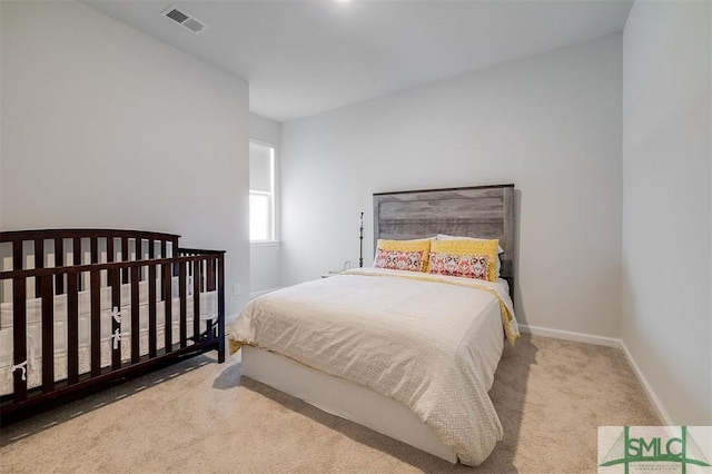 carpeted bedroom with visible vents and baseboards