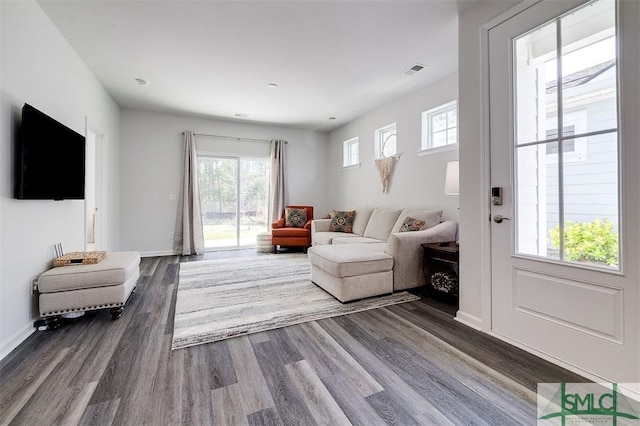 living room with visible vents, dark wood-type flooring, and baseboards