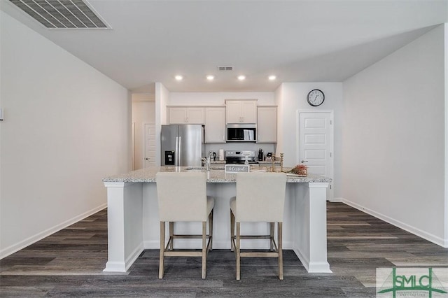 kitchen featuring a kitchen island with sink, visible vents, appliances with stainless steel finishes, and a sink