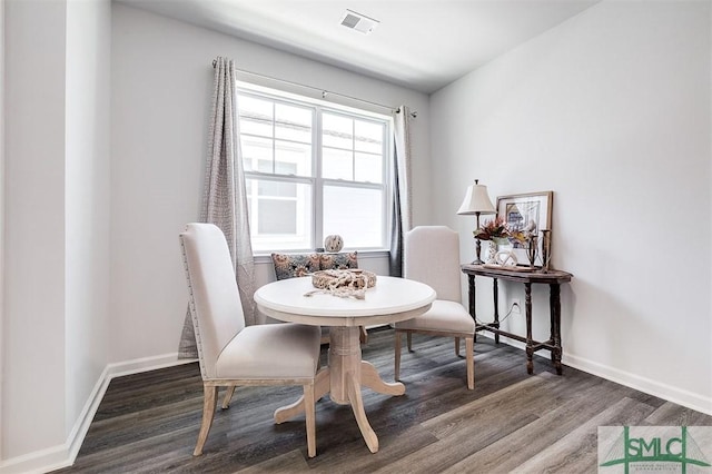 dining space with wood finished floors, visible vents, and baseboards