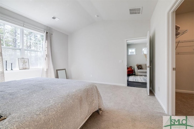 bedroom with lofted ceiling, carpet flooring, baseboards, and visible vents