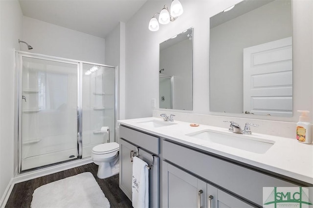 bathroom featuring a sink, wood finished floors, and a shower stall