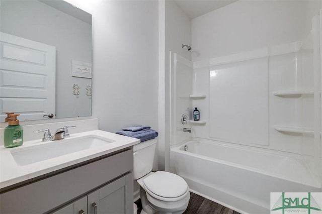 bathroom featuring bathing tub / shower combination, toilet, wood finished floors, and vanity