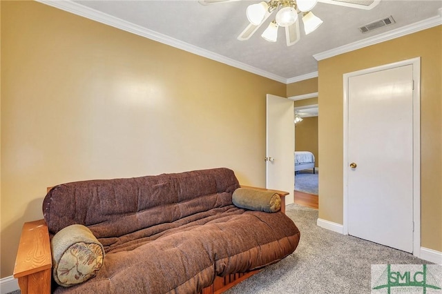 carpeted living area with visible vents, baseboards, ornamental molding, and a ceiling fan